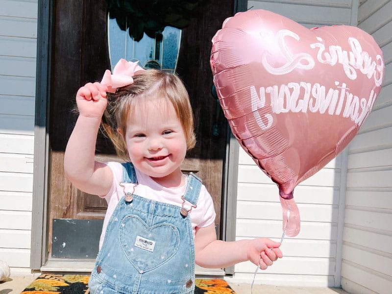 Evelyn Hamm, de 3 años, sostiene un globo para celebrar su segundo 